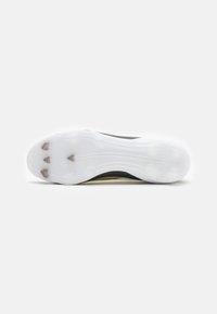 Sole di scarpa sportiva nera e gialla. Presenta una base in gomma bianca con punte di trazione, design curvo e superficie testurizzata per una migliore aderenza.