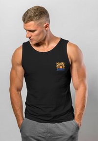 Schwarzes Tanktop mit runder Ausschnitt, das eine kleine Grafik von Sonne und Wasser in Orange und Blau auf der Vorderseite aufweist. Weicher Stoff, lässige Passform.