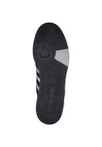 Czarna podeszwa buta z teksturowanym gripem, z okrągłym detalem na środku, ukośnymi paskami oraz wyraźnie widocznym logo "adidas".