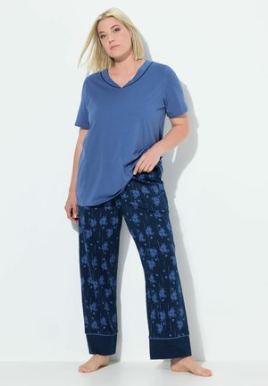 Modrá krátkoztrmá V-neck blůza ve spojení s námořnicky modrými kalhotami s květinovým vzorem, které mají rovný střih a manžety na nohavicích. Měkká, lehká tkanina.
