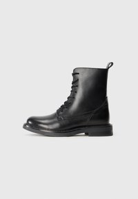 Black leather ankle boots with a smooth finish, lace-up design, and a round toe. Features a low flat sole and reinforced stitching.
