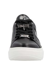 Baskets en cuir noir avec des semelles blanches contrastantes. Les caractéristiques comprennent des lacets noirs, une décoration en forme de libellule argentée et un logo rayé sur la languette.