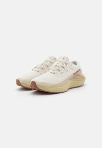 Leichte Laufschuhe aus weißem Mesh mit beigen Akzenten und einer strukturierten Gummisohle. Verfügt über ein sicheres Schnürsystem und ein atmungsaktives Design.