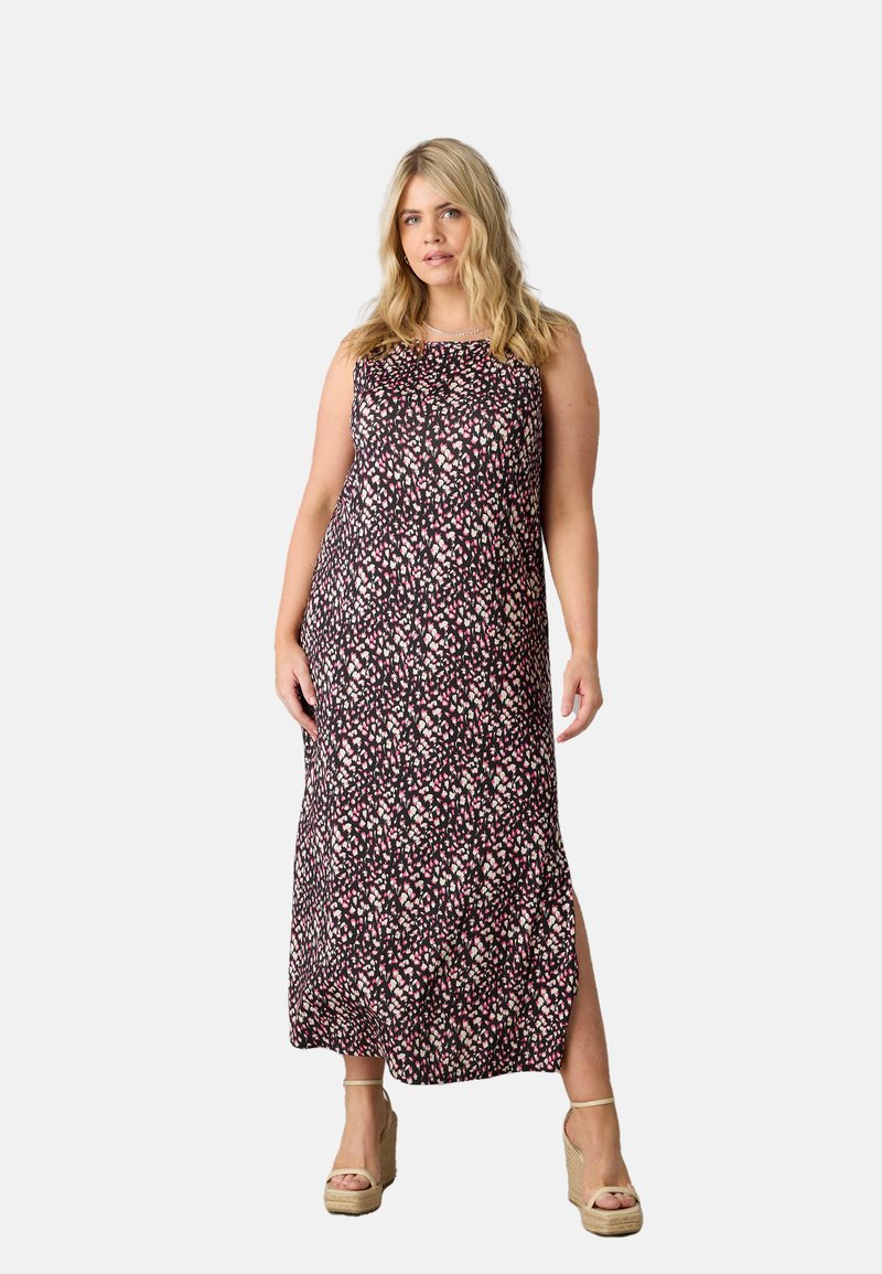 Maxi šaty z černé látky s růžovým a bílým květinovým vzorem, s bočním rozparkem a volným střihem. Celkový vzhled doplňují ploché espadrilky.