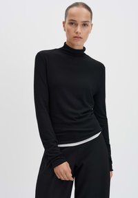 Schwarzes Rollkragenoberteil mit langen Ärmeln aus einem glatten, dehnbaren Stoff und einer taillierten Passform. Es hat einen minimalistischen Stil und einen eng anliegenden Kragen.