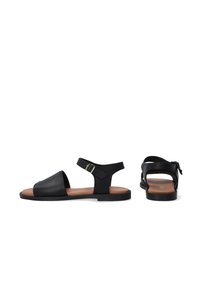 Zwarte leren sandalen met een open teenontwerp, enkelband met gesp en platte zool. Bruin voetbed complementeert het zwarte exterieur.