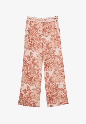 Közelkép a középrészről, amely virágmintás nadrágot rickrack szegéllyel, hord egy félmeztelen hasú személy, akinél egy kéz látható.