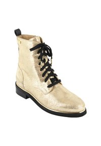 Botín de cuero metálico dorado con cordones negros, suela plana y punta redondeada. Presenta una textura suave y un sutil patrón de grietas.