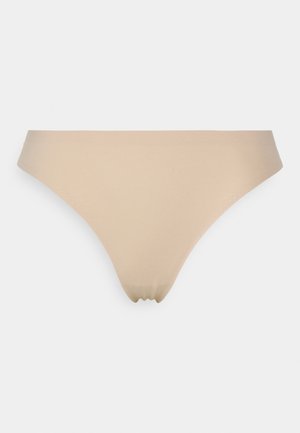 Beige thong underwear made of smooth fabric, featuring a seamless design and a minimalistic shape without embellishments or patterns.
