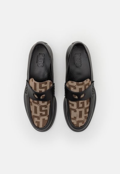 Schwarze Lederloafers mit braunem textilem Obermaterial, das ein geometrisches Muster aufweist. Enthält einen Riemen mit einem Ausschnittdetails.