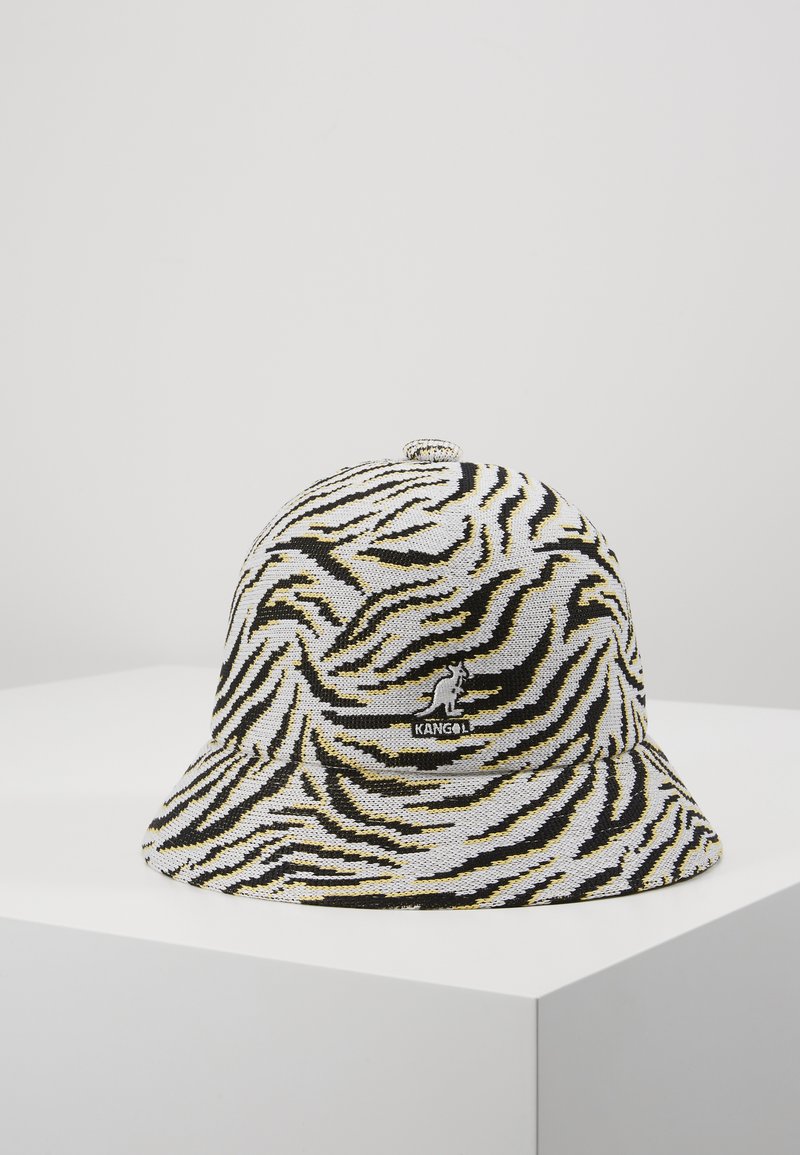 Gorra tipo cubo de Kangol con un tejido texturizado que presenta un patrón de cebra en negro, blanco y amarillo; logo bordado en la parte frontal.