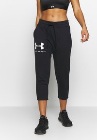 Schwarze, kürzere Sweatpants mit elastischem Taillenbund, Kordelzug und Under Armour-Logo in Weiß am linken Bein. Weicher, leichter Stoff.