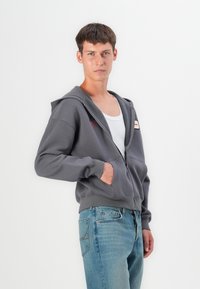 Gray zip-up hoodie made of cotton blend fabric. Features a kangaroo pocket, adjustable drawstring hood, and contrast stitching.