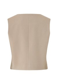 Beżowy bezrękawnik o strukturalnym, kanciastym kroju. Gładka faktura, minimalna liczba szwów i prosta linia dołu. Idealny do nakładania warstw.