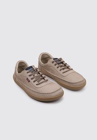 Zapatos casuales beige hechos de material suave con diseño de cordones, suela de goma y sutiles detalles de costura.
