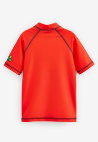 Kortærmet rash guard i klart rødt stof med sort syning. Har en høj krave og et lille logo på venstre ærme.