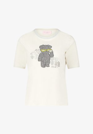 Kremowa koszulka z krótkim rękawem, zdobiona grafiką misia w dzianinie z pomponami, konturowaną na szaro z żółtymi akcentami i subtelnymi kropkami w tle.