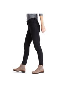 Černé slim-fit džíny s středním pasem, spárované s hnědými semišovými kotníkovými botami s elastickými bočními panely a nízkým podpatkem.