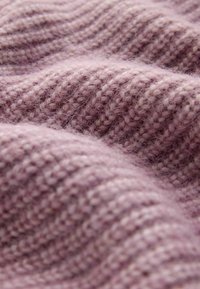 Gestrickter Stoff in sanftem Lavendelton mit einem strukturierten Muster aus abwechselnd erhabenen und flachen Maschen, das Tiefe und Wärme verleiht.