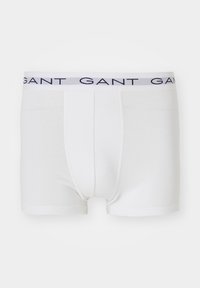 Boxers blancs pour hommes avec un logo GANT bleu marine sur la ceinture élastique, présentés à plat sur un fond neutre.