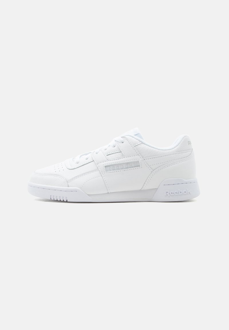 Baskets basses blanches Reebok avec fermeture à lacets, pointe perforée et semelle de marque sur fond blanc.