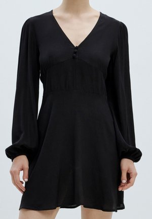 Schwarzes langärmeliges Kleid mit V-Ausschnitt, gerafftem Oberteil und Knopfdetails. Hergestellt aus leichtem Stoff mit einem fließenden, lässigen Schnitt und ausgeweitetem Saum.