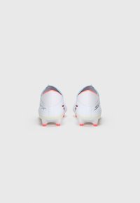 White soccer cleats with light blue accents, pink detailing on the sole, and a textured upper. Features a sleek design and visible branding.