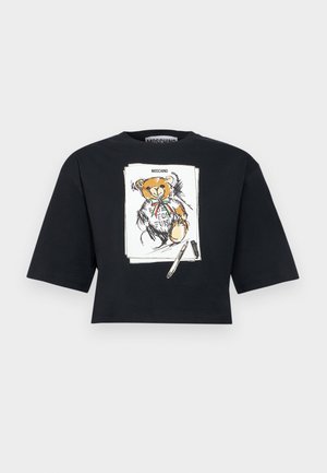 Musta lyhyt T-paita, jossa leveät hihat ja piirros nallekarhusta, joka pitää rusetti päässään ja kynää kädessään, Moschino-brändäys.