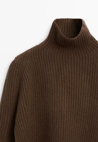 Brązowy sweter z golfem o prążkowanym splocie, z długimi rękawami, pokazany złożony na płasko na białym tle.