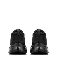 Des chaussures de sport noires avec un dessus en tissu texturé, un col rembourré et une semelle en caoutchouc solide et épaisse dotée d'un motif de semelle.