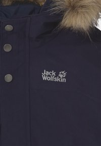 Giacca parka blu navy con cappuccio foderato in pelliccia, bottoni a pressione argentati e logo grigio sul petto. Tessuto texturizzato con accenti a contrasto.