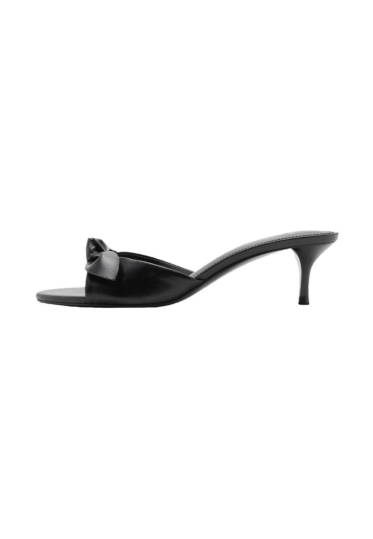 Black leather slip-on mules with a bow accent, open toe, and a slim high heel. Smooth texture and minimalistic design.