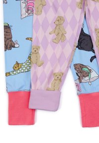 Dos piernas de pijama: una azul claro con gráficos de animales, la otra rosa con un estampado de diamantes y motivos de osos marrones. Presenta puños en contraste.
