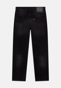 Svarta jeans i denim med rak passform, midjeband med etikett och två bakfickor med subtila sömnadsdetaljer.