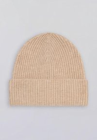 Gorro de punto en beige con textura acanalada y puño doblado. Material suave con un ajuste ceñido. Mide aproximadamente 25 cm de altura.