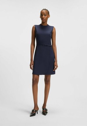 Navy fitted dress with a high neckline and sleeveless design, featuring a side panel and a small belt detail at the waist.