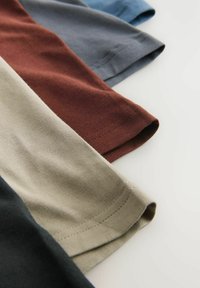 Fünf Stoff-T-Shirt-Ärmel in verschiedenen Farben: schwarz, beige, braun, blau und grau. Weiche Baumwolle mit genähten Säumen und glatter Textur.