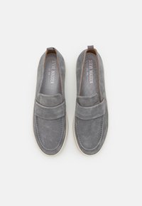 Chaussures gris en daim à enfiler avec un col rembourré, des accents élastiques sur les côtés et des semelles en caoutchouc de couleur claire. Dotées de coutures tonales et d'un logo à l'intérieur.