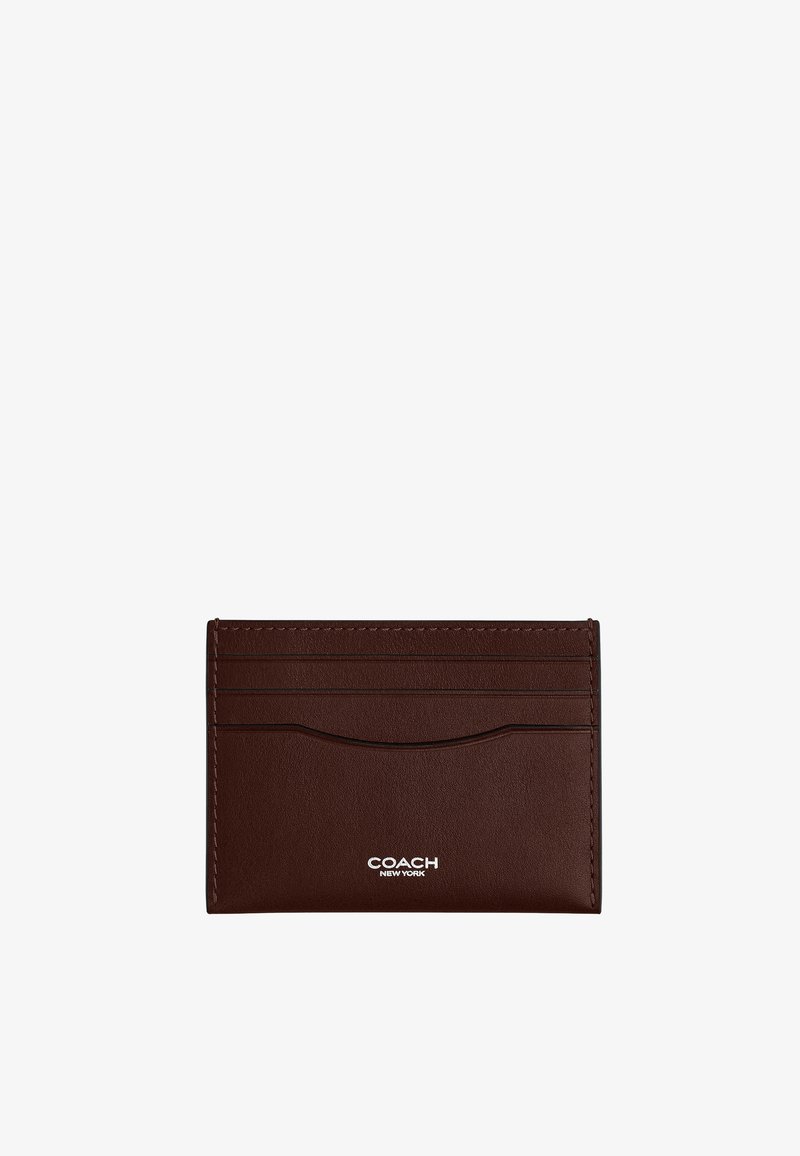 Porte-cartes en cuir marron foncé avec quatre emplacements pour cartes et logo blanc « COACH NEW YORK » centré en bas.