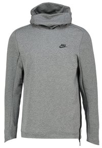 Grå Nike hoodie med hög krage, texturerad tyg, långa ärmar och en svart logotyp på bröstet. Har sidofickor med dragkedja.