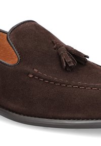 Brązowe zamszowe mokasyny z okrągłym czubkiem, skórzanymi akcentami i frędzlami z przodu. Miękka tekstura i przeszywane wykończenie.