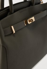 Sac à main en cuir texturé gris foncé avec deux poignées supérieures, doté d'un fermoir métallique doré et de détails de couture subtils.