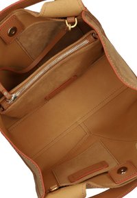 Tan leren tote bag interieur met een suede afwerking, gouden rits en oranje accenten. Heeft meerdere compartimenten en een drukknoopsluiting.