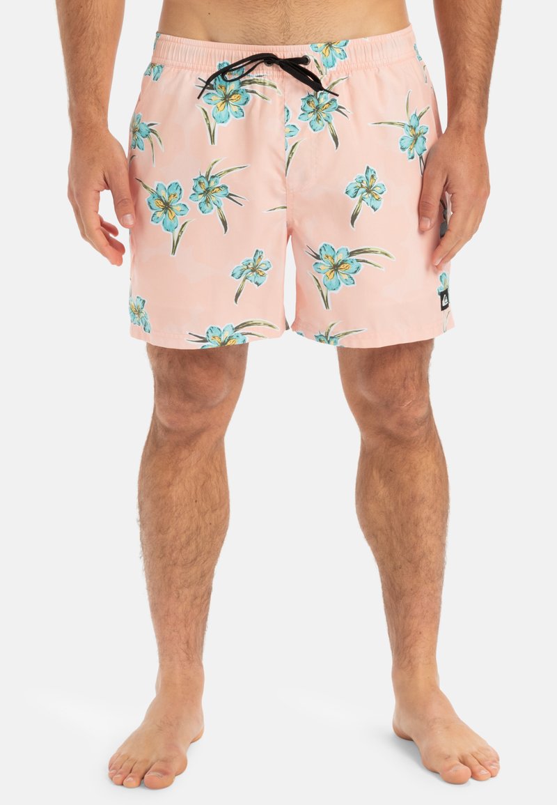 Ljusrosa badshorts med ett tropiskt blommönster i blått och grönt, med resårmidja och svart dragsko för justerbarhet.