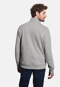 Sweatshirt gris à col montant, avec des poignets et un ourlet côtelés, fabriqué en tissu doux avec une texture unie.