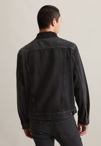 Zwarte spijkerjack met een klassiek ontwerp, voorzien van een kraag, zijsEntidademen en knoopaccenten op de mouwen en achterkant.