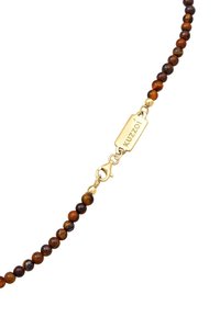 Brun tigeröga pärlhalsband med guldfärgad hårdvara och lås. Har en liten guldsymbol med "Kuzoi" gravyr. Släta, runda pärlor.