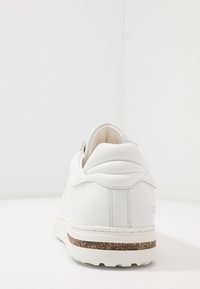 Baskets en cuir blanc présentant une forme arrondie, des accents cousus et une semelle intérieure en liège. Semelle en caoutchouc à profil bas avec finition texturée.