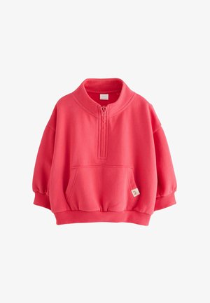 Bluză sport coral cu guler înalt, fermoar pe jumătate, buzunar mare frontal și mansete striate. Fabricată din material moale, cu o croială lejeră.