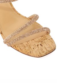 Strappy cork sandal with a square toe. Features shimmering, rose gold glitter straps and a natural cork-textured footbed.